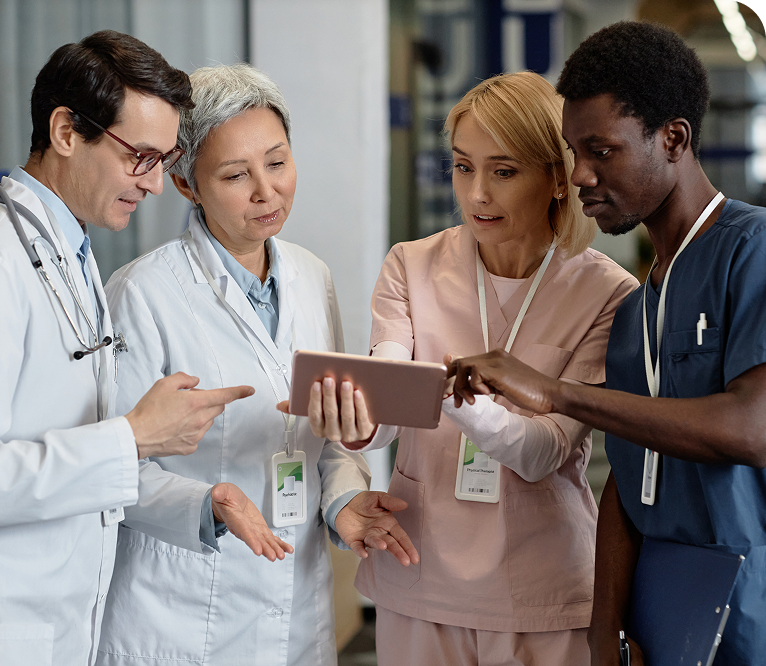 a group of people in scrubs looking at a tablet